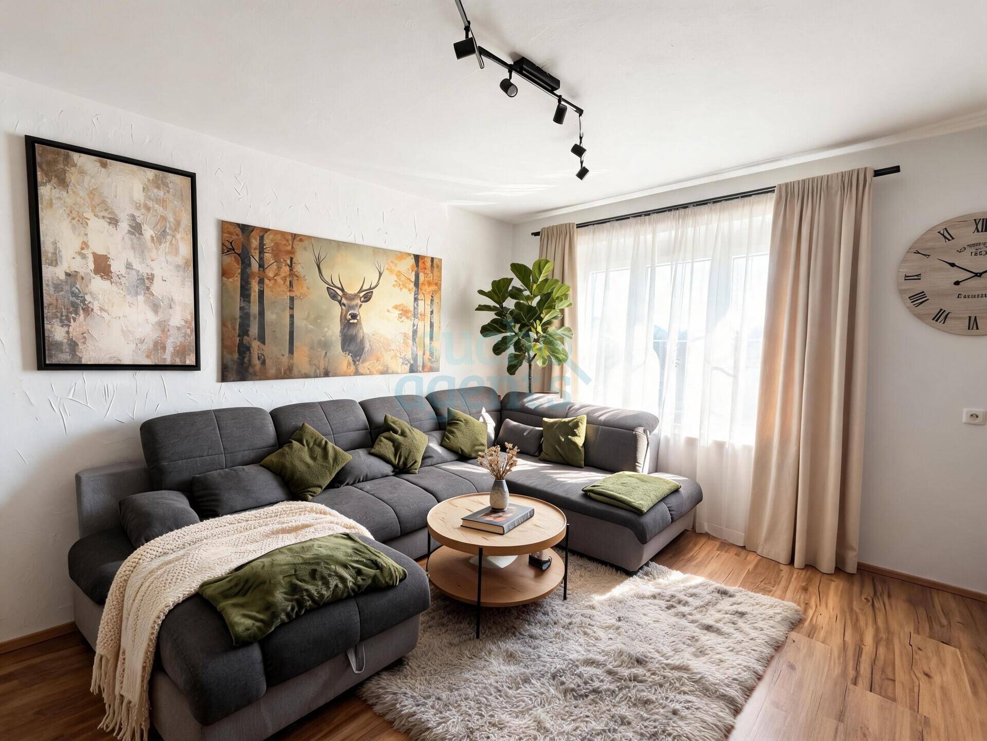 Helles Wohnzimmer mit großem Ecksofa, Holzboden und dekorativen Hirschmotiven an den Wänden.