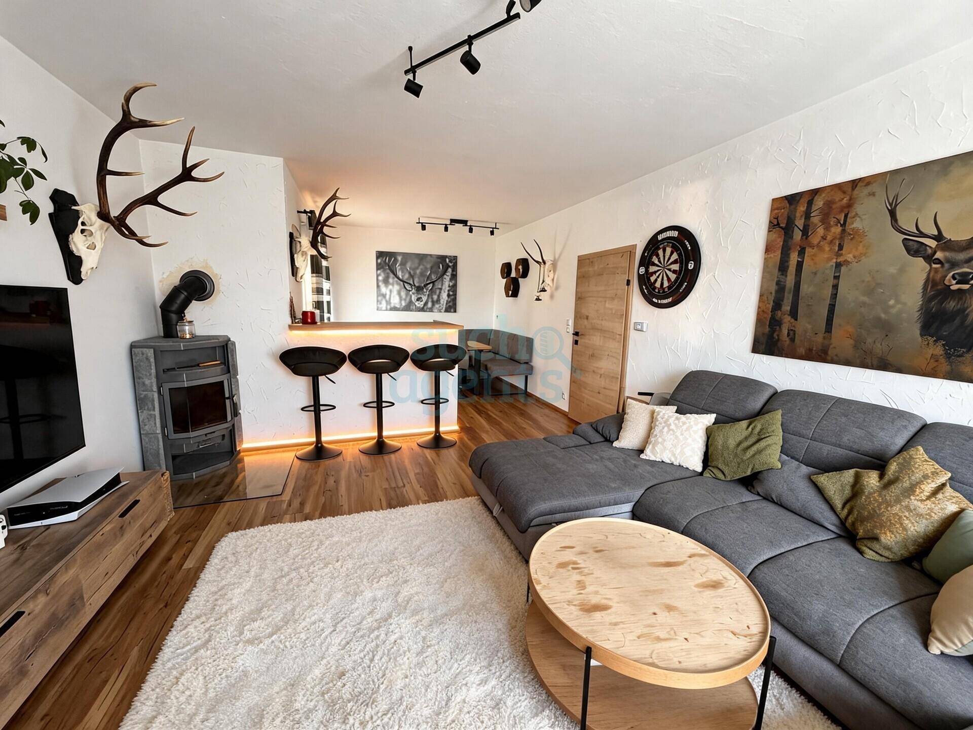 Wohnbereich mit gemütlichem Sofa, Holzofen und einer integrierten Bar für gesellige Abende.
