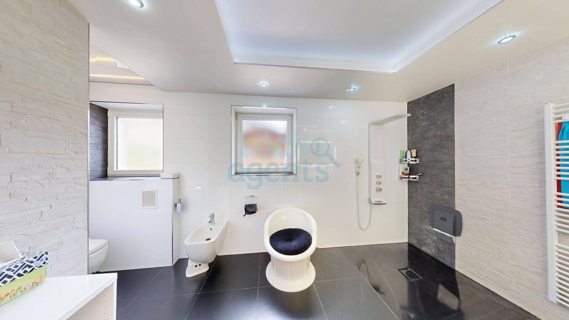 Modernes Badezimmer mit ebenerdiger Dusche, Bidet, Wand-WC und Fenster für Tageslicht.