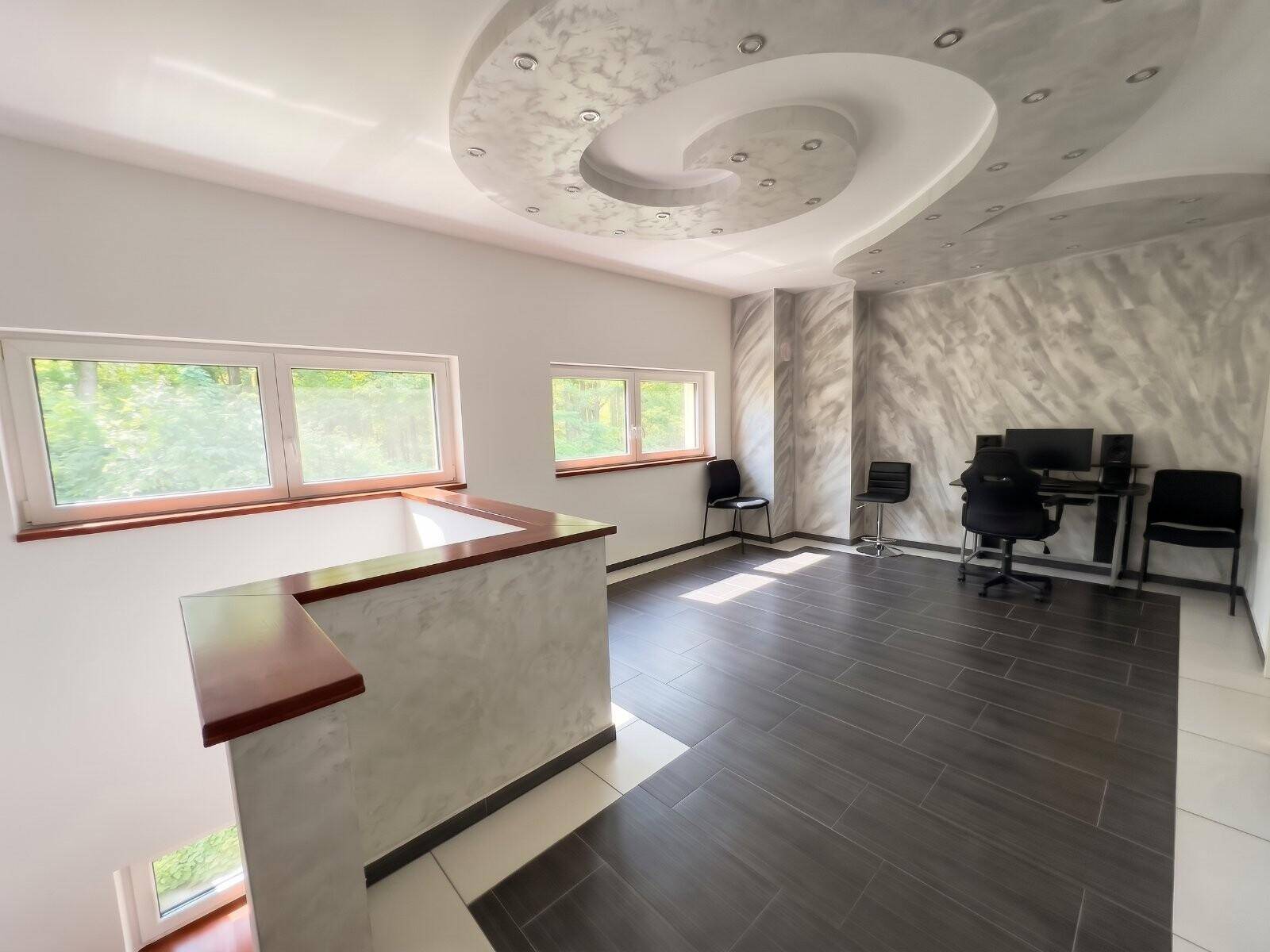 Heller offener Raum im Obergeschoss mit modernem Decken-Design und Arbeitsbereich.