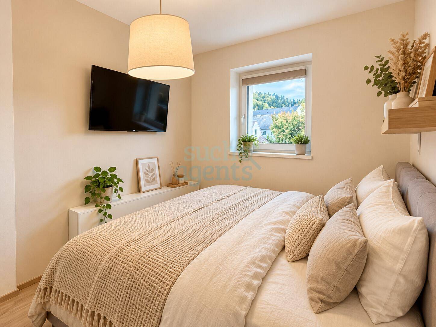 Gemütliches Schlafzimmer mit Doppelbett, Fernseher und Blick ins Grüne.