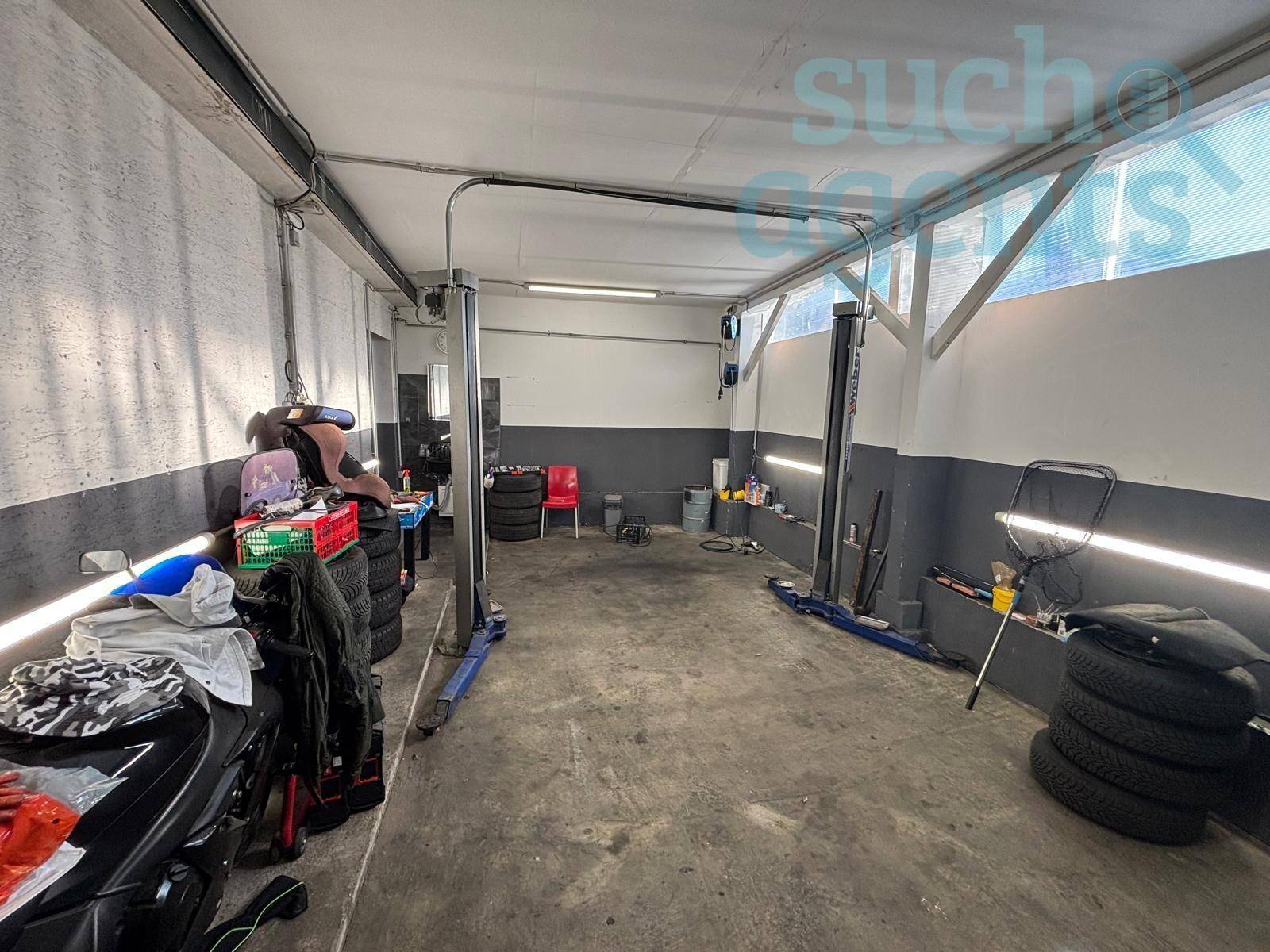 Geräumige Werkstattgarage mit zwei Hebebühnen, Betonboden und viel Platz für Fahrzeuge und Lagerung.