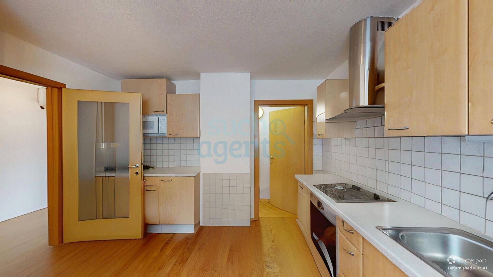 Funktionale Küche mit hellen Holzschränken, Fliesenrückwand und integrierten Geräten.
