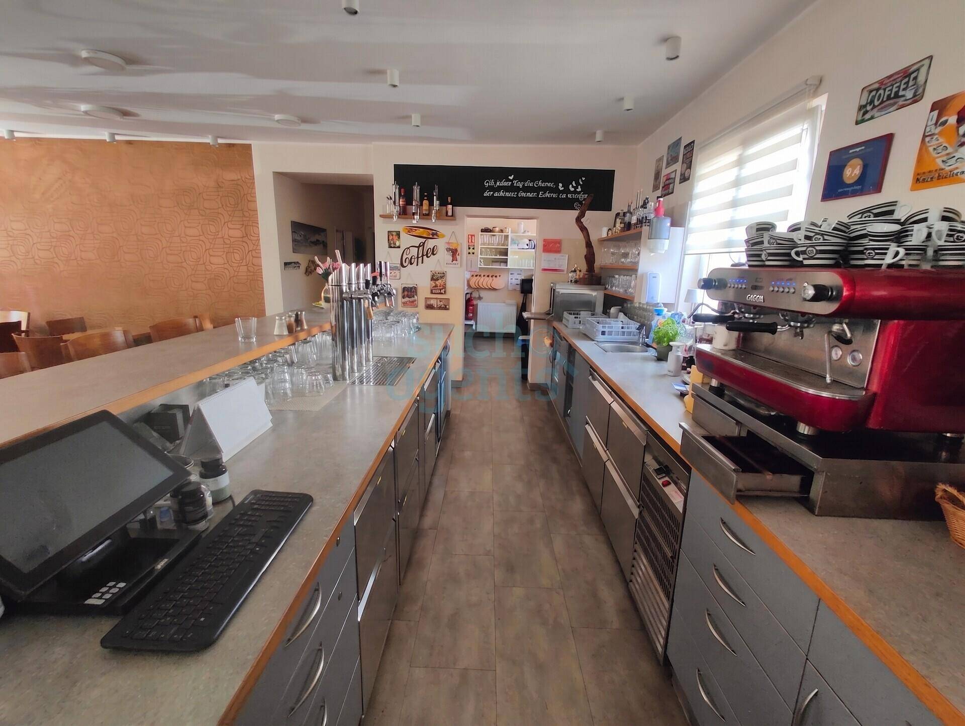 Langer Thekenbereich mit Zapfanlage, Kaffeemaschine und Kassensystem in einem Gastronomiebetrieb.
