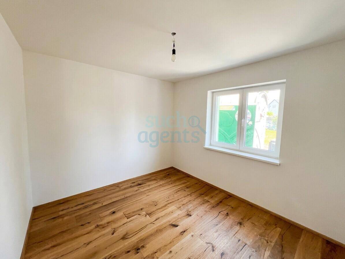 Weiteres helles Zimmer mit Holzboden und einem Fenster, ideal als Schlaf- oder Arbeitszimmer.