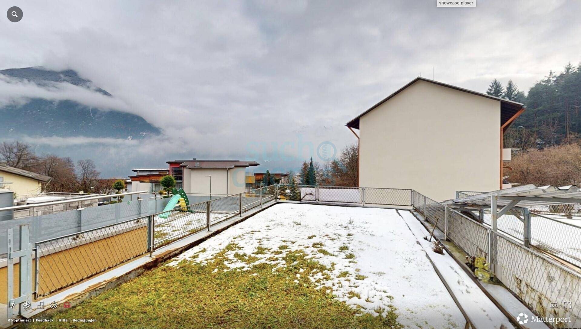 Außenansicht des Gebäudes mit schneebedecktem Gartenbereich und beeindruckendem Bergblick im Hintergrund.