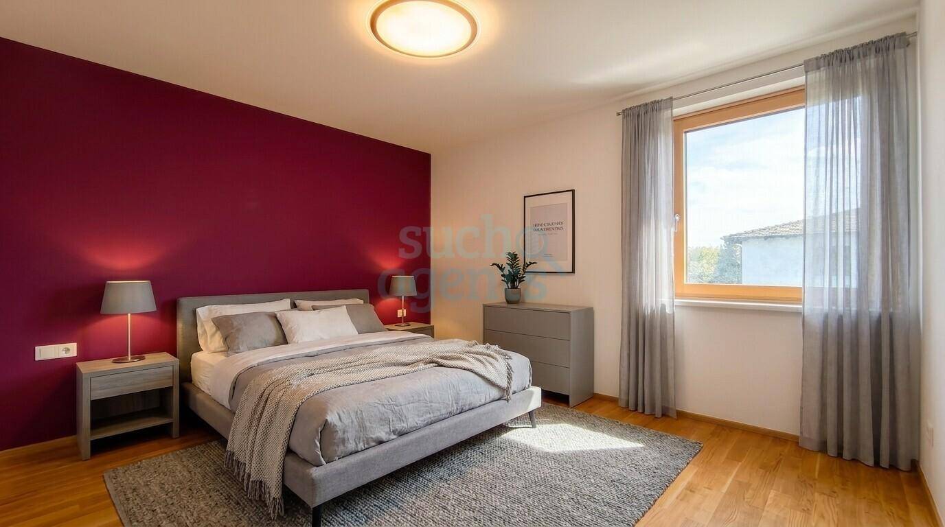 Schlafzimmer mit Holzboden, Doppelbett, Nachttischen und einer farbigen Akzentwand.