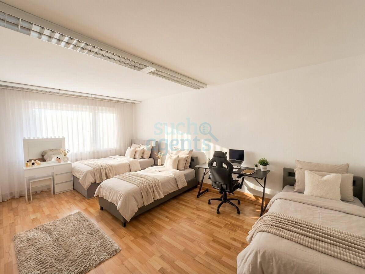 Geräumiges Schlafzimmer mit drei Einzelbetten, Schreibtisch und viel Tageslicht.
