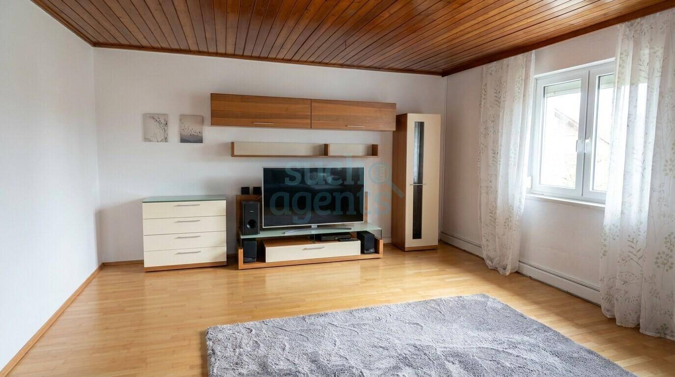 Gemütliches Wohnzimmer mit Holzdecke, Parkettboden und moderner Medieneinheit.