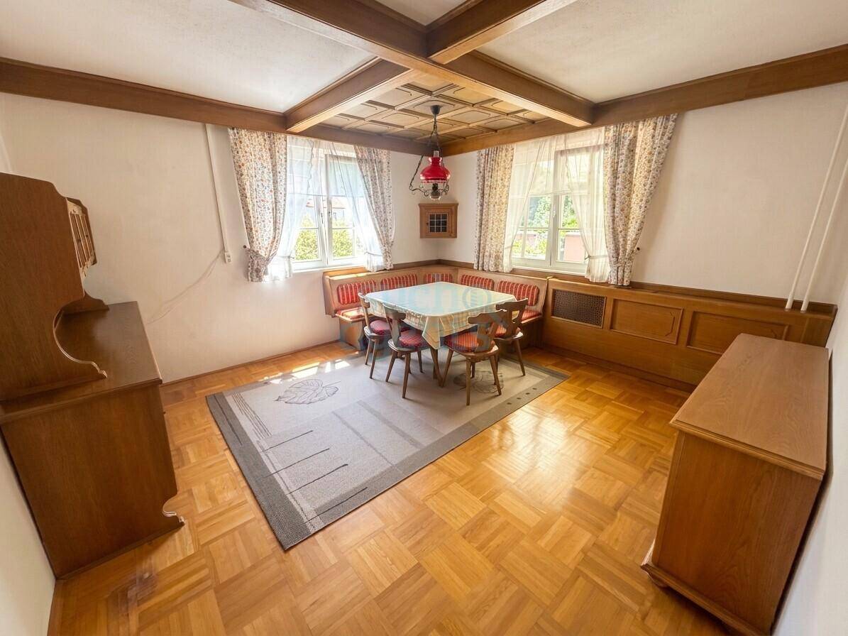 Traditionelles Esszimmer mit Holzbalkendecke, Holzvertäfelung und Parkettboden.