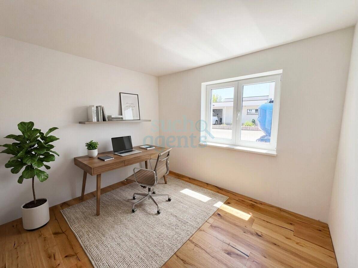 Helles Arbeitszimmer mit Holzboden, Schreibtisch und großem Fenster.