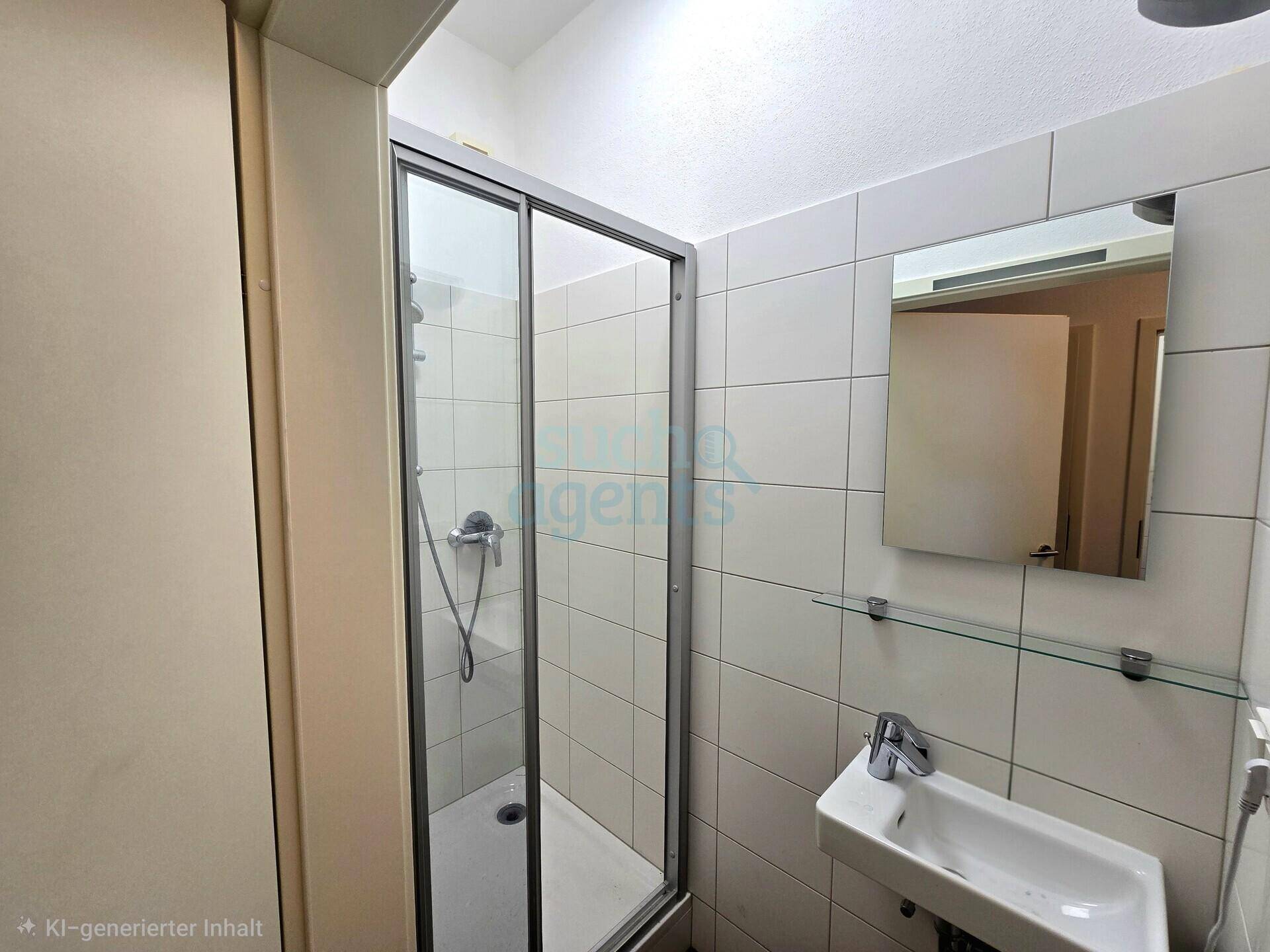 Funktionales Badezimmer mit Duschkabine, Waschbecken und Wandspiegel, komplett gefliest.