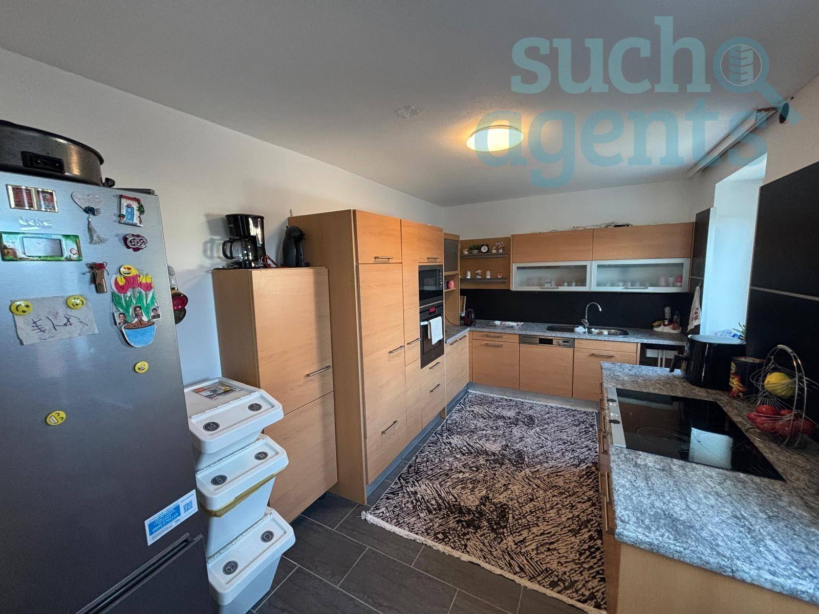 Funktionale Küche mit Holzschränken, Granitarbeitsplatte und Fliesenboden.