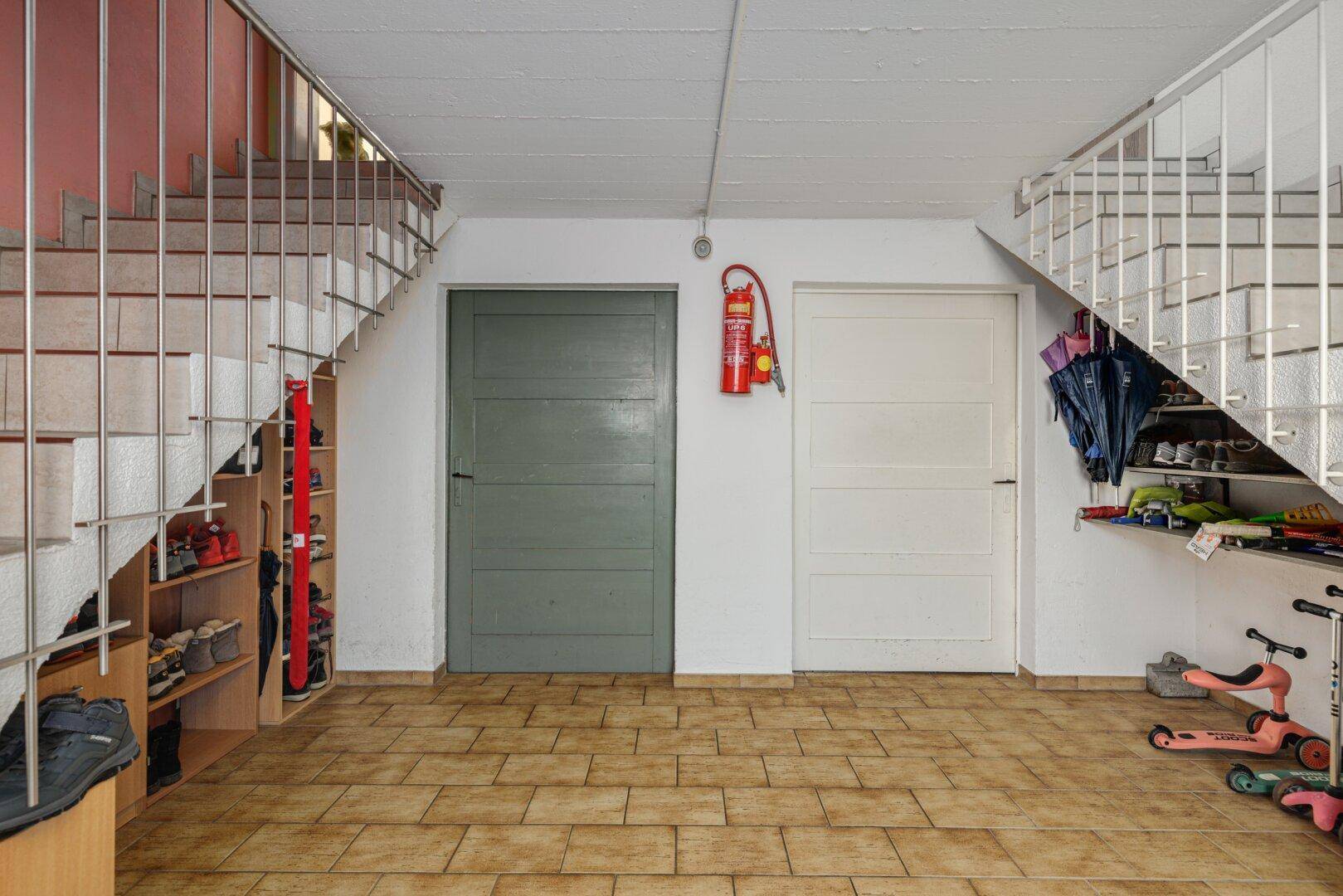Kellerflur mit Treppenaufgängen und praktischem Stauraum unter den Treppen.