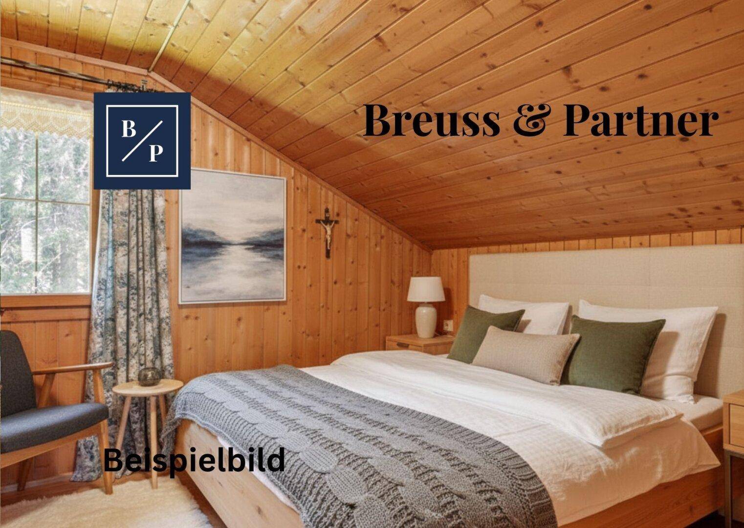 Gemütliches Schlafzimmer im Dachgeschoss mit Holztäfelung, schräger Decke und Doppelbett.