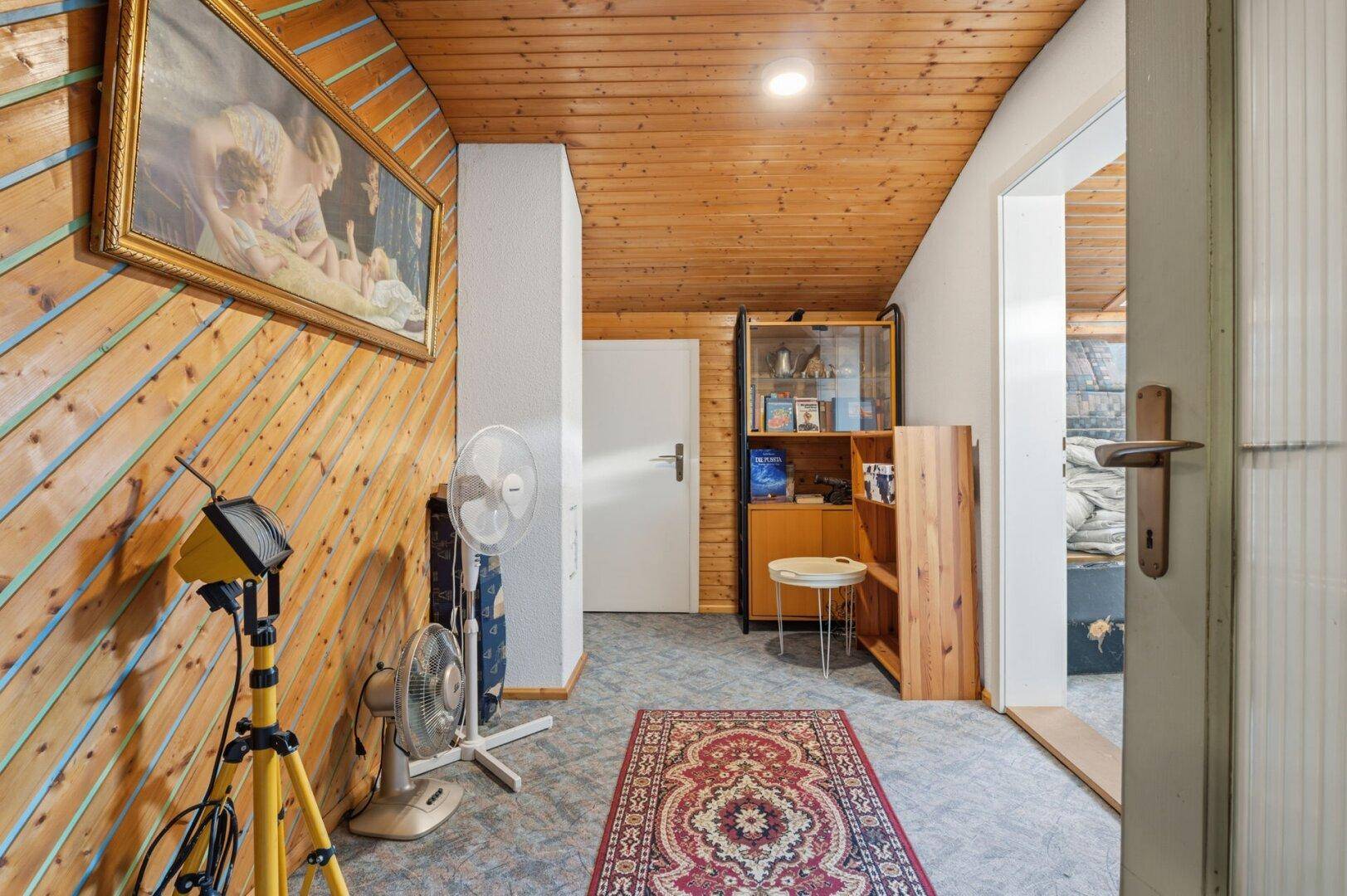 Flur mit Holzvertäfelung, Teppich und Zugang zu weiteren Räumen.