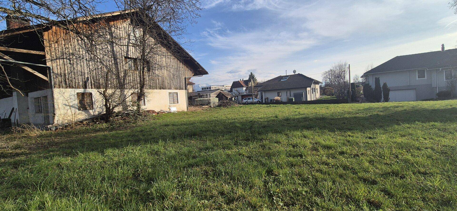 Außenansicht des Gebäudes mit weitläufiger Rasenfläche und ländlicher Umgebung unter blauem Himmel.