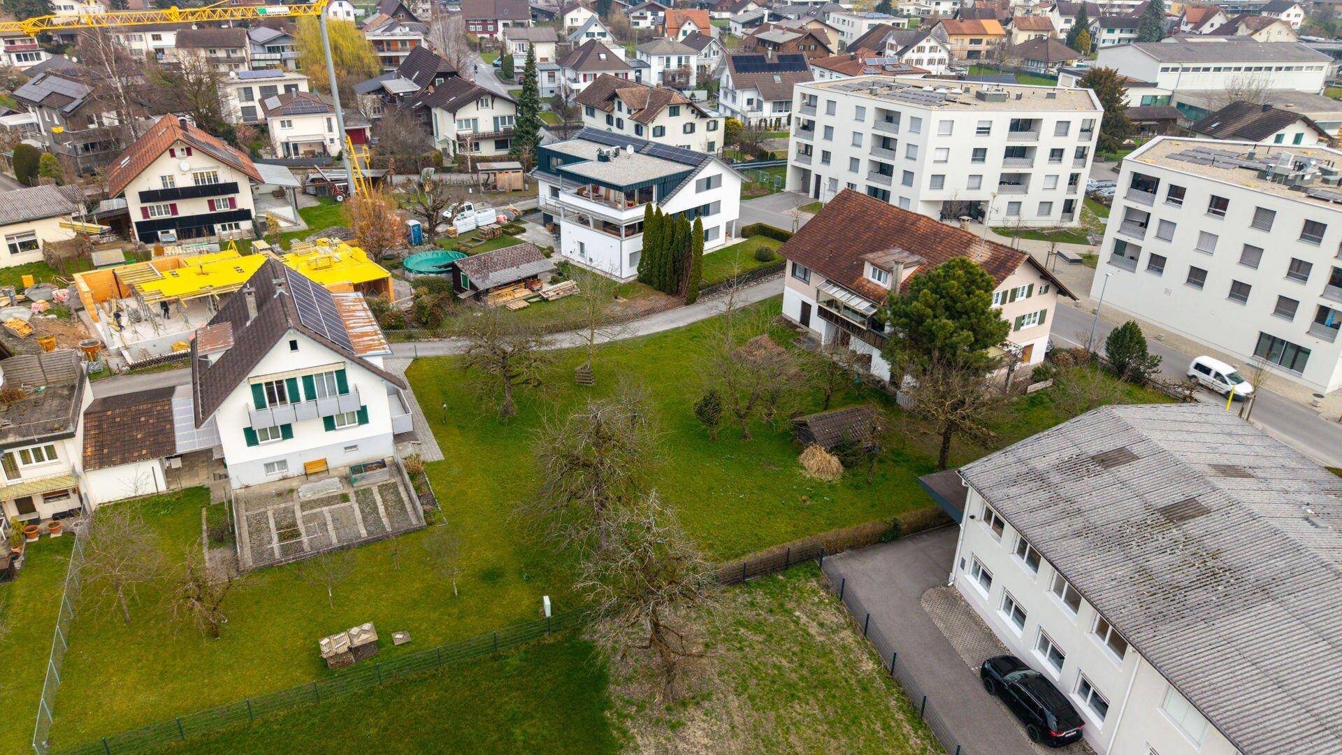 Nahaufnahme aus der Vogelperspektive eines Wohngebiets mit verschiedenen Häusern, Gärten und Baustellen.