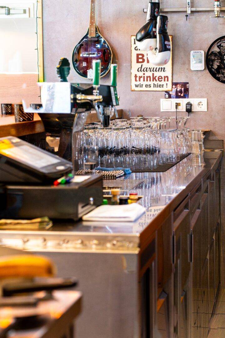 Detailansicht der Bar mit Gläsern, Zapfanlage und Kassensystem.