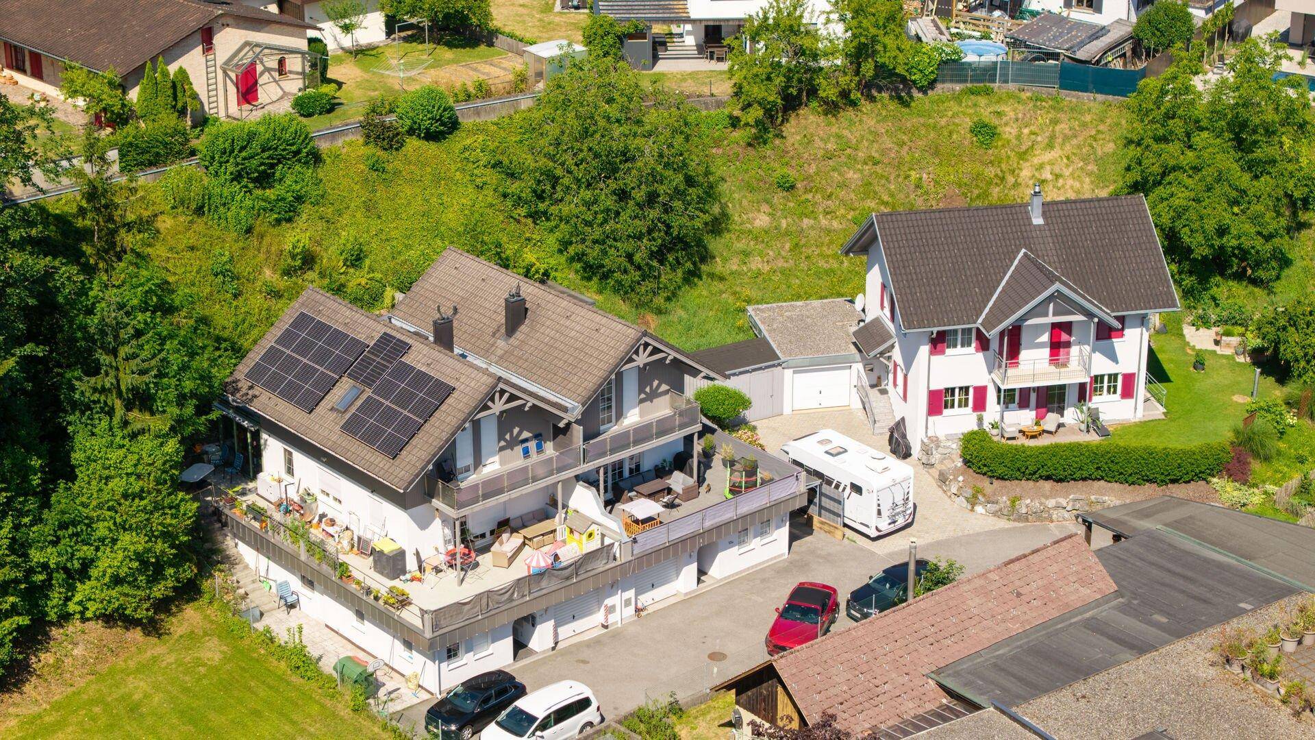 Luftaufnahme des Hauses mit Photovoltaikanlage auf dem Dach und umliegender Natur.