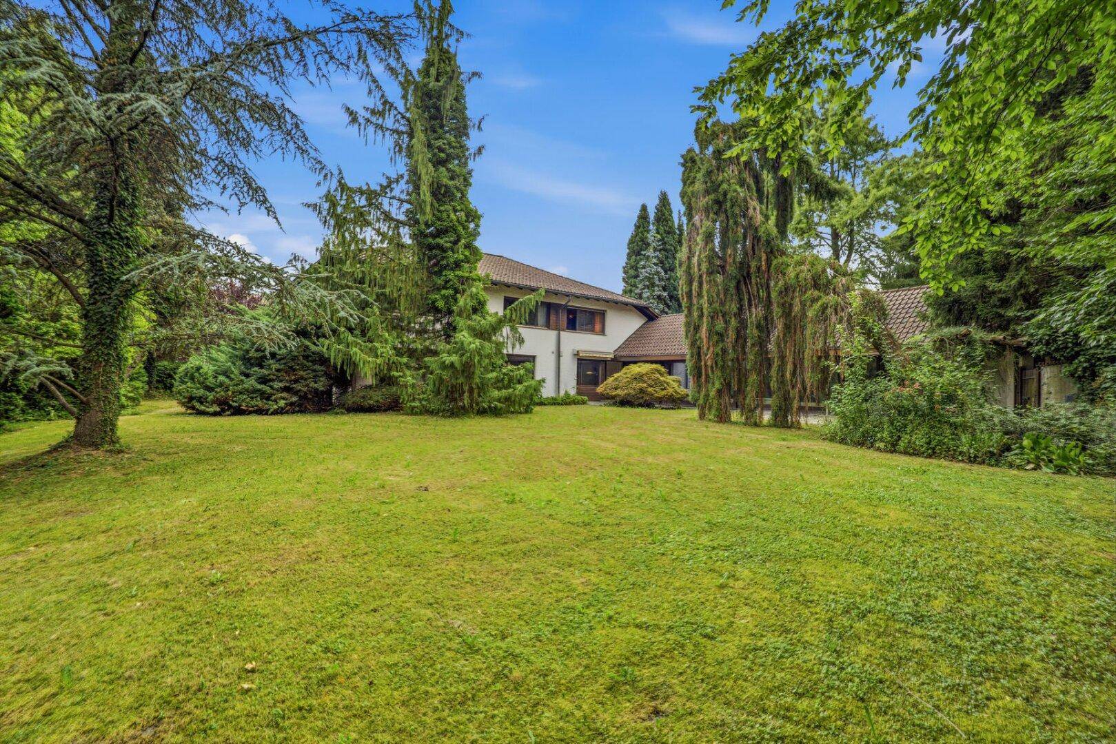 Großer, gepflegter Garten mit altem Baumbestand und Blick auf das weitläufige Grundstück.