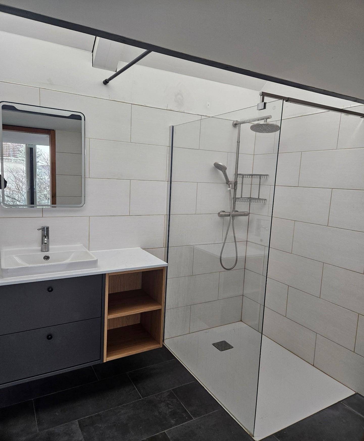 Modernes Badezimmer mit begehbarer Dusche, großformatigen Fliesen und Einzelwaschbecken.
