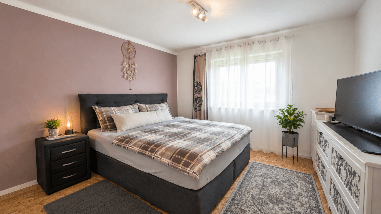 Modern eingerichtetes Schlafzimmer mit Doppelbett und hellem Fenster für viel Tageslicht.