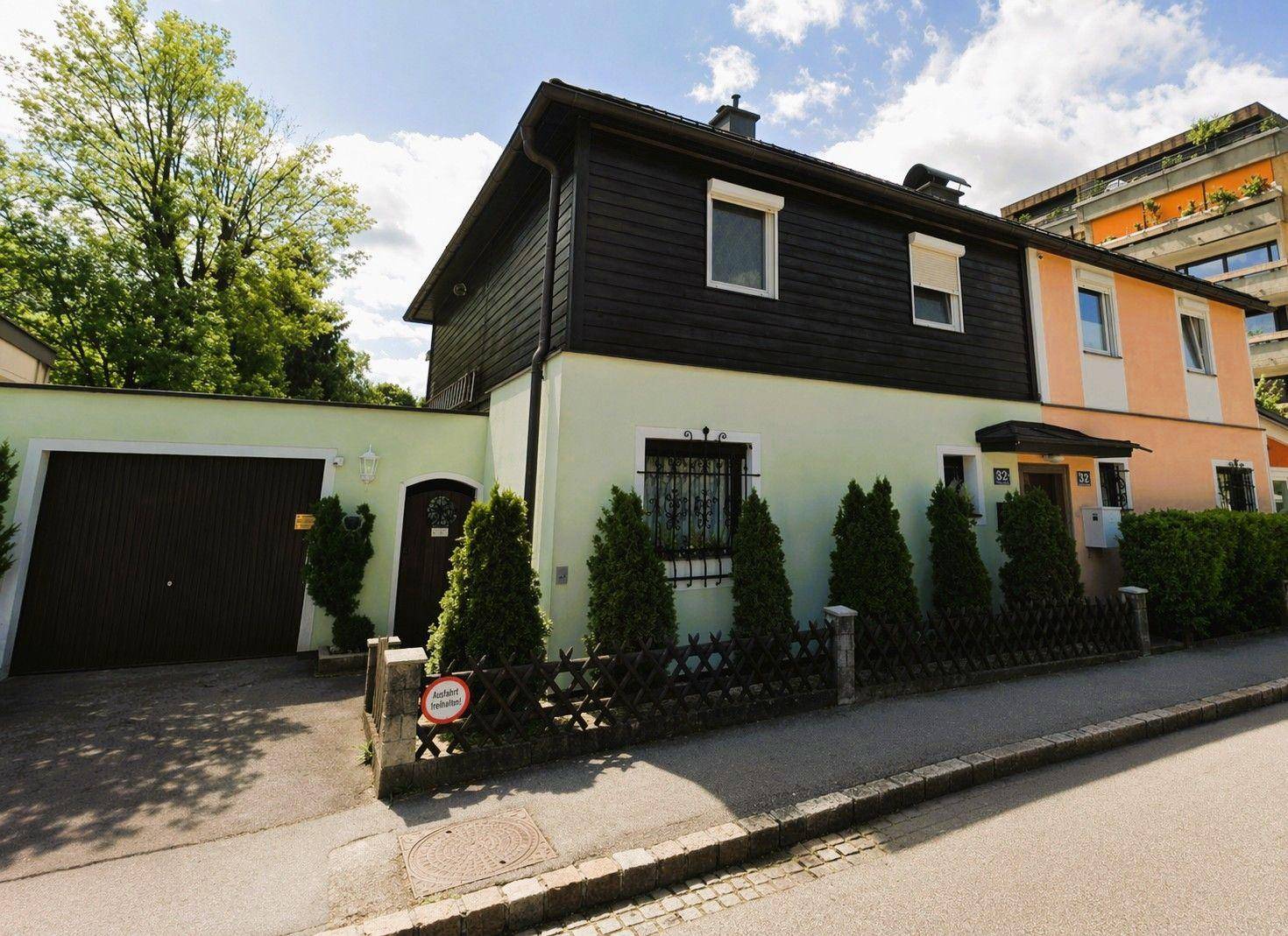 Vorderansicht des Hauses mit Garage, gepflegtem Vorgarten und Zufahrt.
