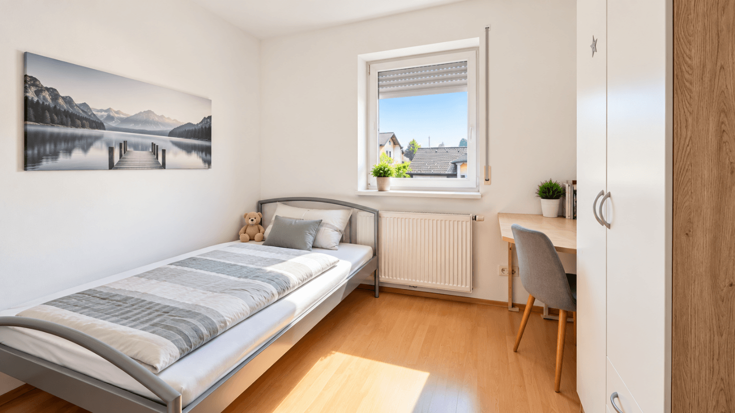 Kinder- oder Gästezimmer mit Einzelbett, Schreibtisch und hellem Laminatboden.
