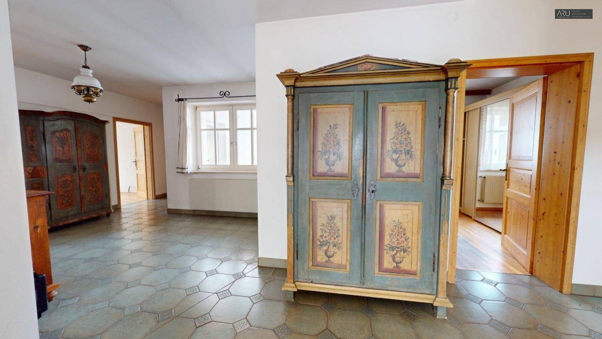 Geräumiger Flur mit Fliesenboden, traditionellen Holzschränken und Zugang zu weiteren Räumen.