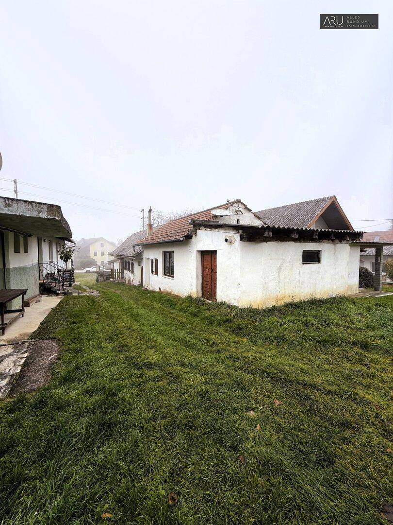 Freistehendes, älteres Wohnhaus mit Satteldach und Rasenfläche in ländlicher Umgebung.