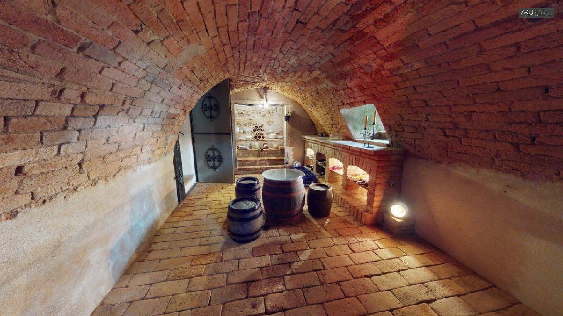 Historischer Weinkeller mit Ziegelgewölbe, Ziegelboden und Holzfässern, ideal für Weinlagerung.