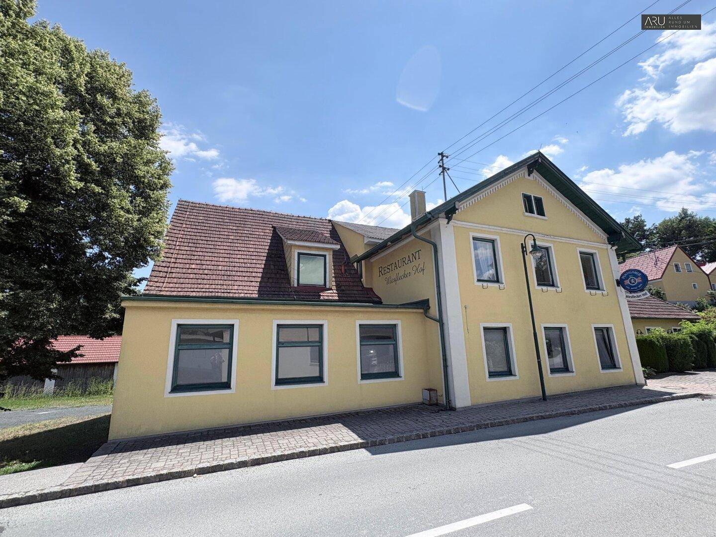 Vorderansicht des Gebäudes mit Restaurantbeschriftung und Blick auf die Straße.