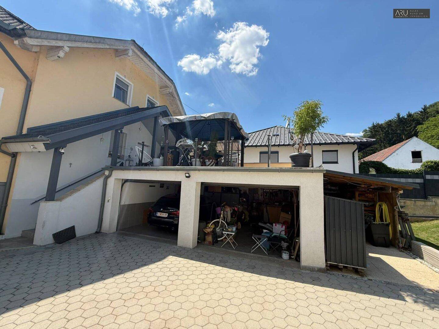 Doppelgarage mit gepflasterter Zufahrt und Abstellbereich.