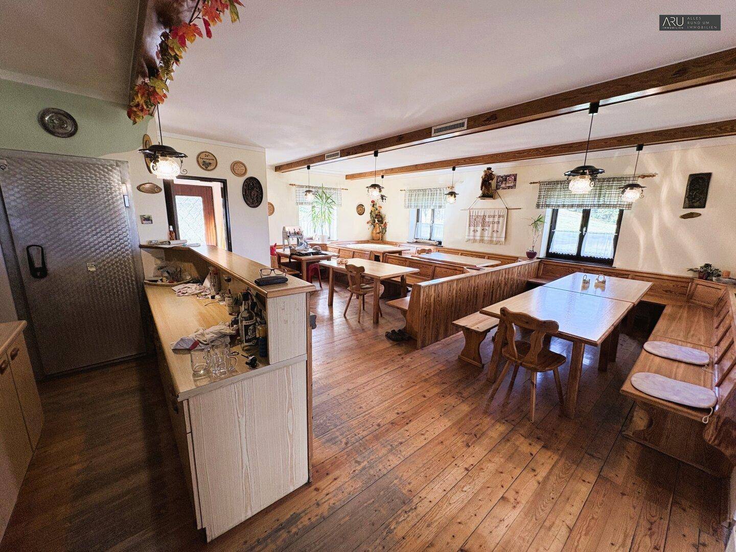 Geräumiger Essbereich im Landhausstil mit Holzböden und traditionellen Möbeln, inklusive Bar.