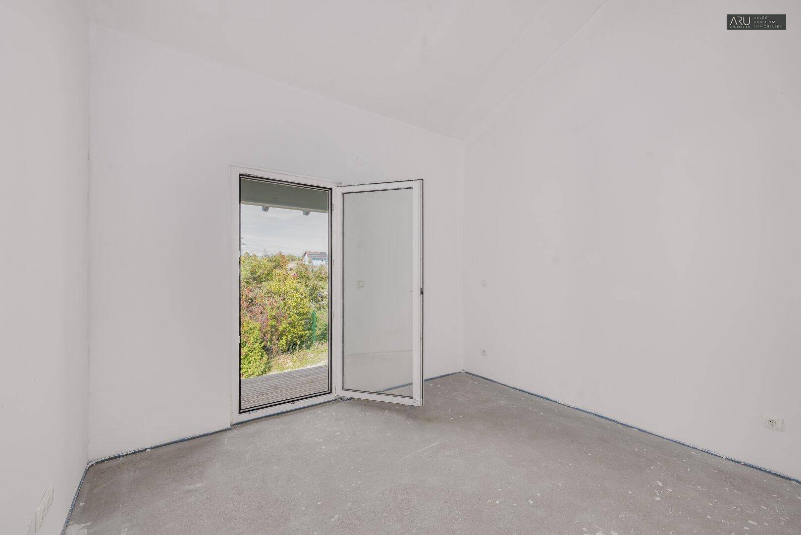 Unfertiges Zimmer mit Zugang zu einem Balkon, bietet viel natürliches Licht und frische Luft.