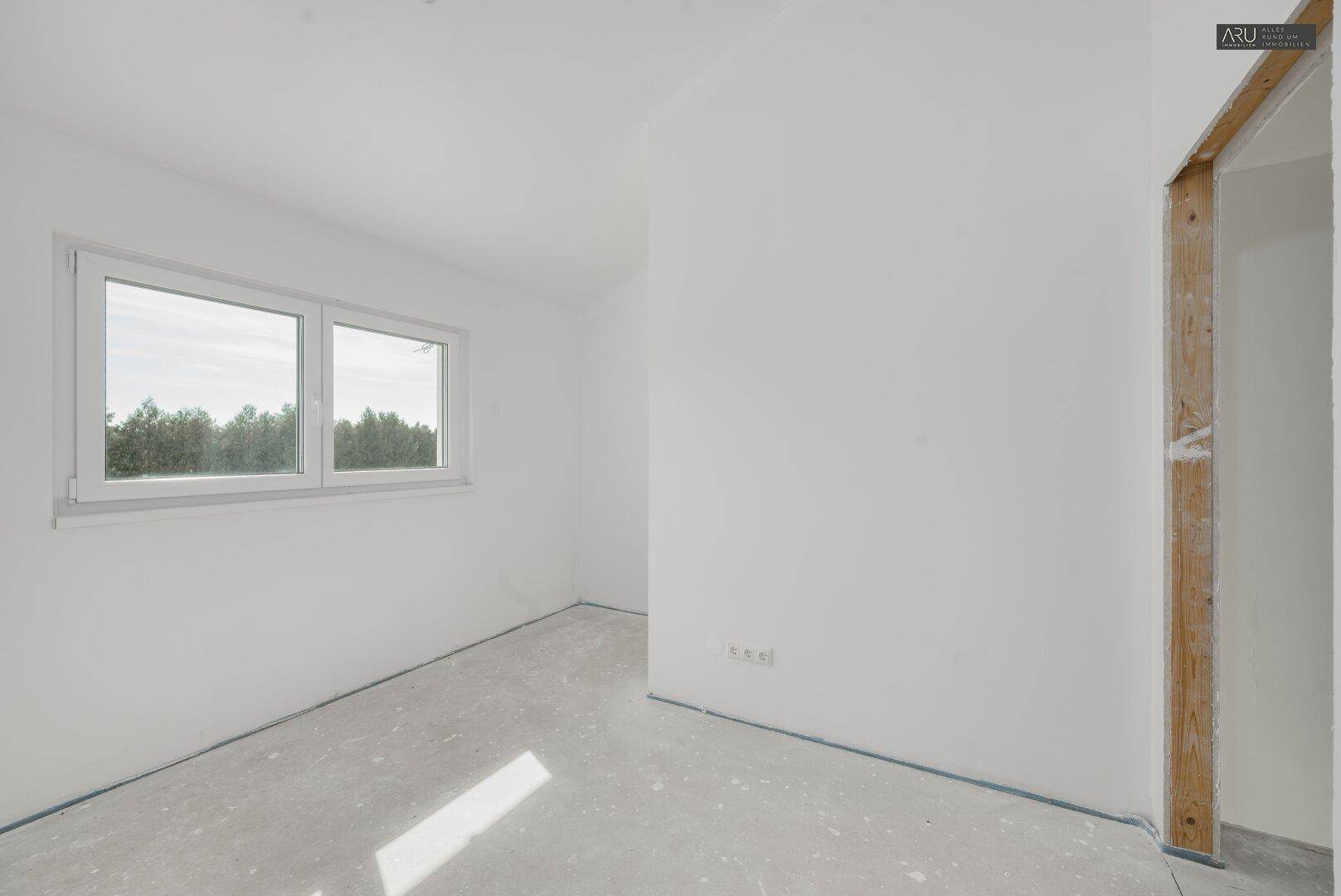 Geräumiges, unfertiges Schlafzimmer mit Fenster und viel Potenzial für individuelle Gestaltung.