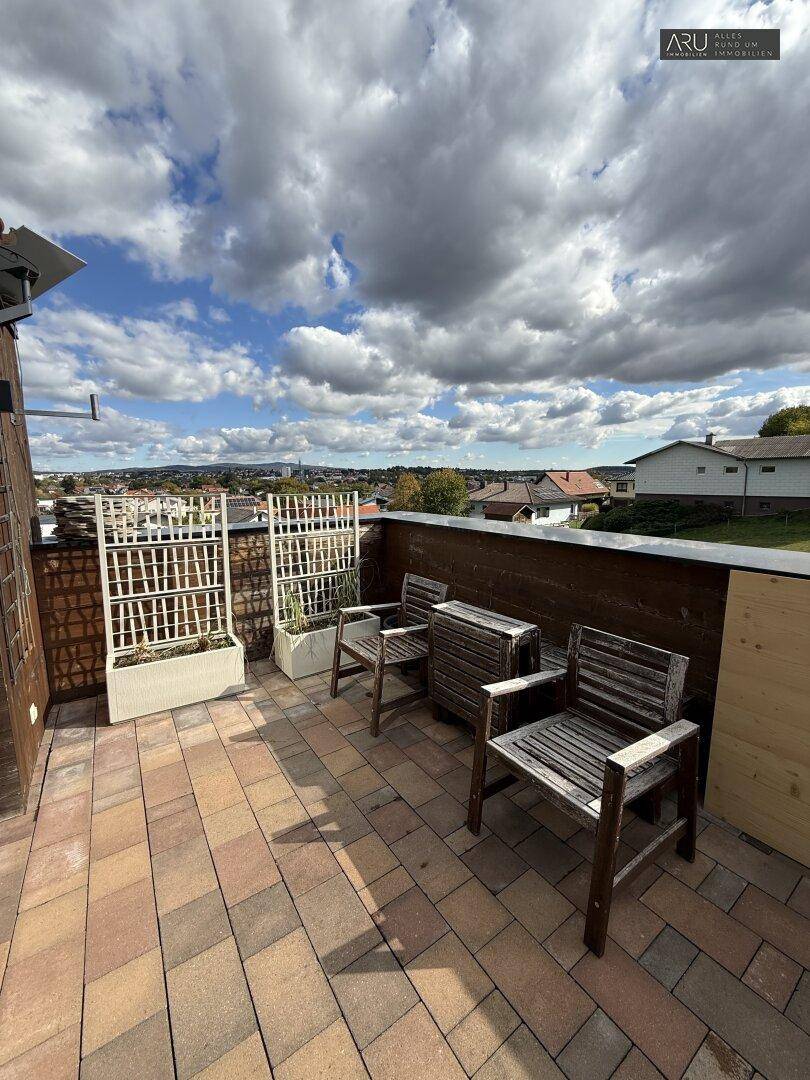 Gemütliche Dachterrasse mit Holzsitzgelegenheiten und weitem Blick über die Landschaft.