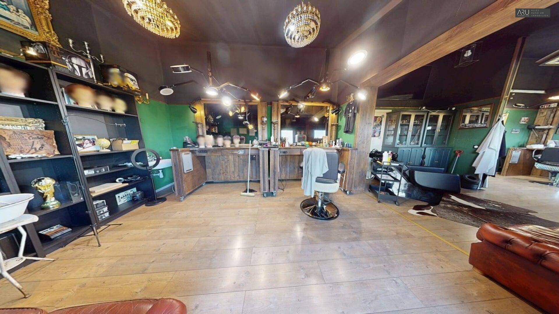 Geräumiger Barbershop mit mehreren Styling-Stationen, Holzfußboden und dunkler Decke.