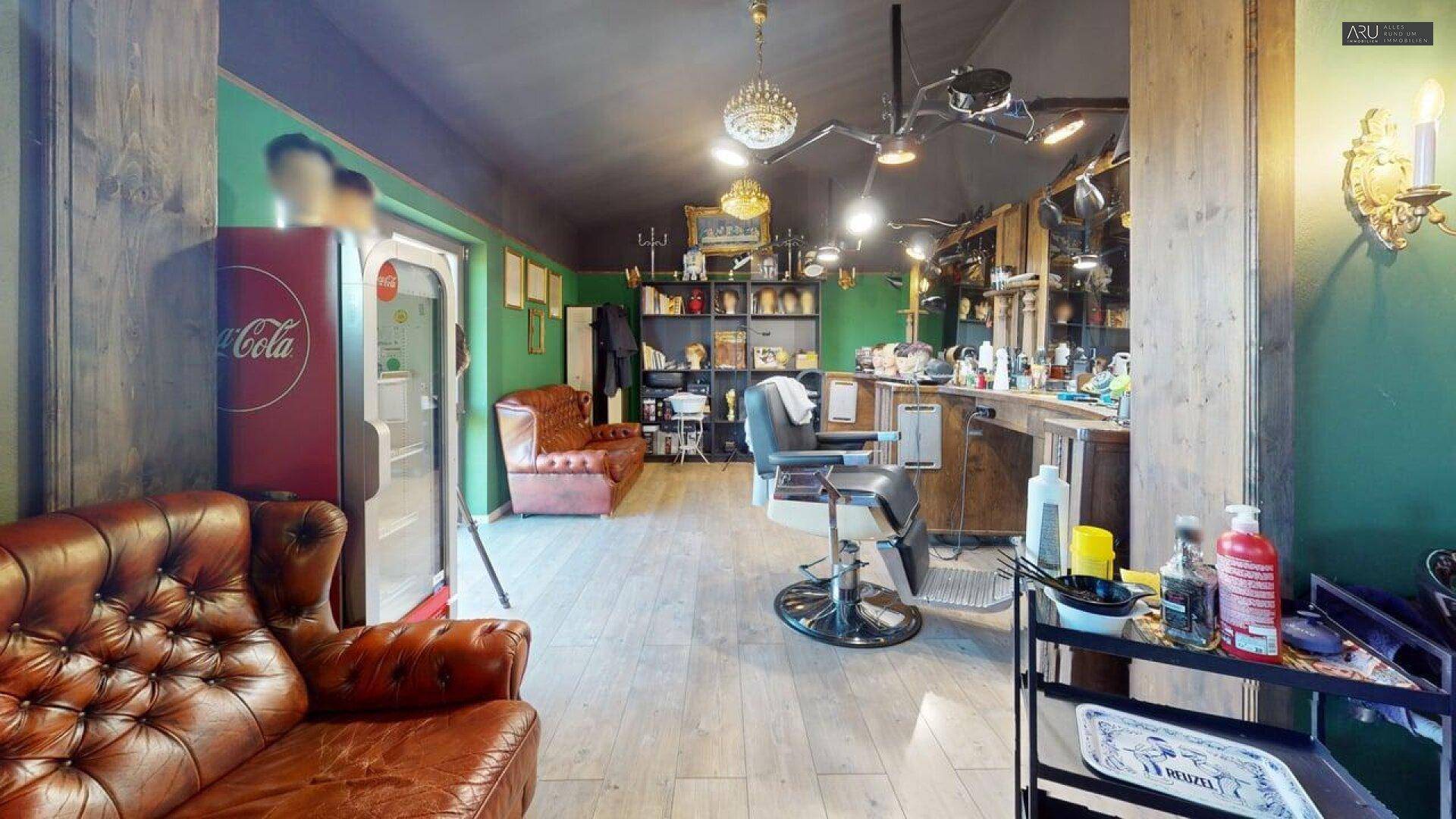 Barbershop mit Vintage-Möbeln, grünen Wänden und Holzfußboden, inklusive Kühlschrank.