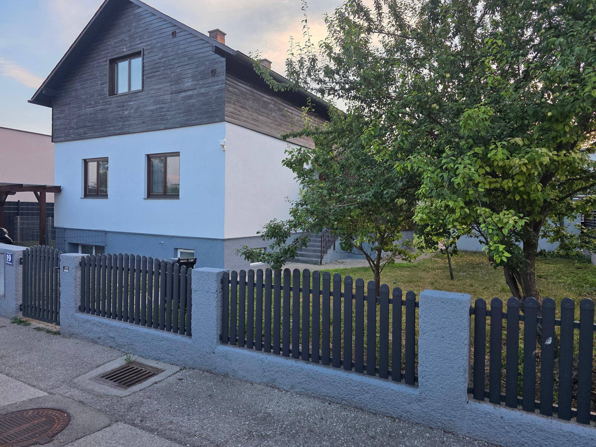 Attraktives Einfamilienhaus mit moderner Fassade, Holzelementen und gepflegtem Vorgarten.