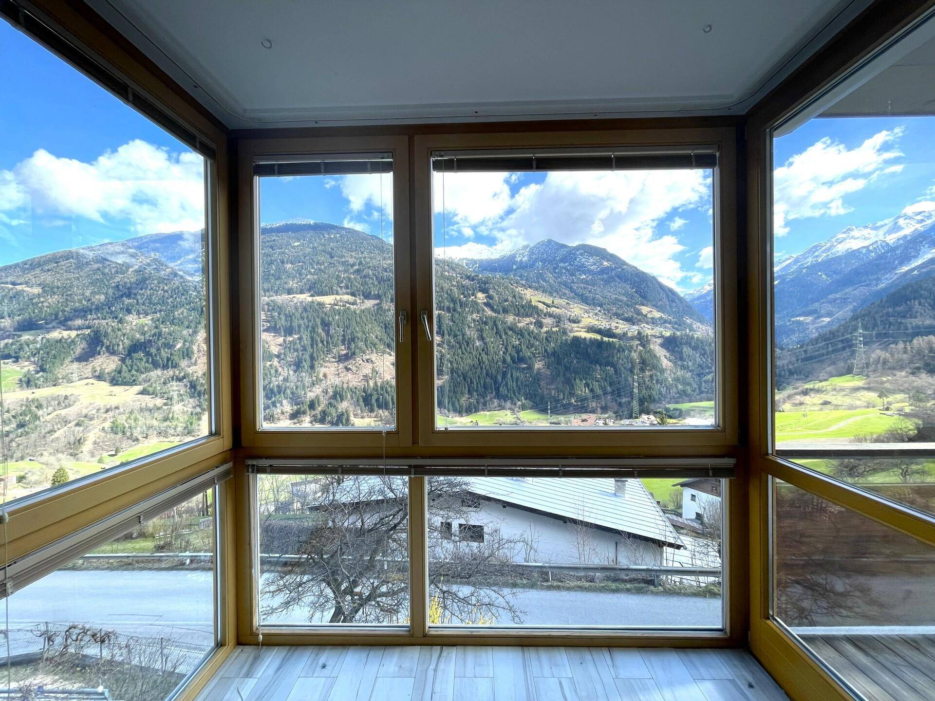 Große Fensterfront im Wohnbereich bietet einen spektakulären Panoramablick auf die Berge.