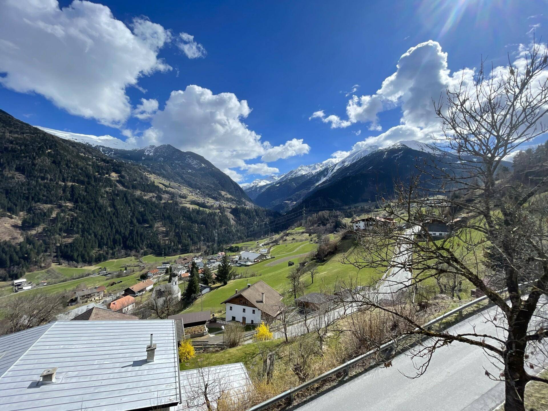 Malerischer Panoramablick auf die Alpenlandschaft mit grünen Tälern und schneebedeckten Gipfeln.