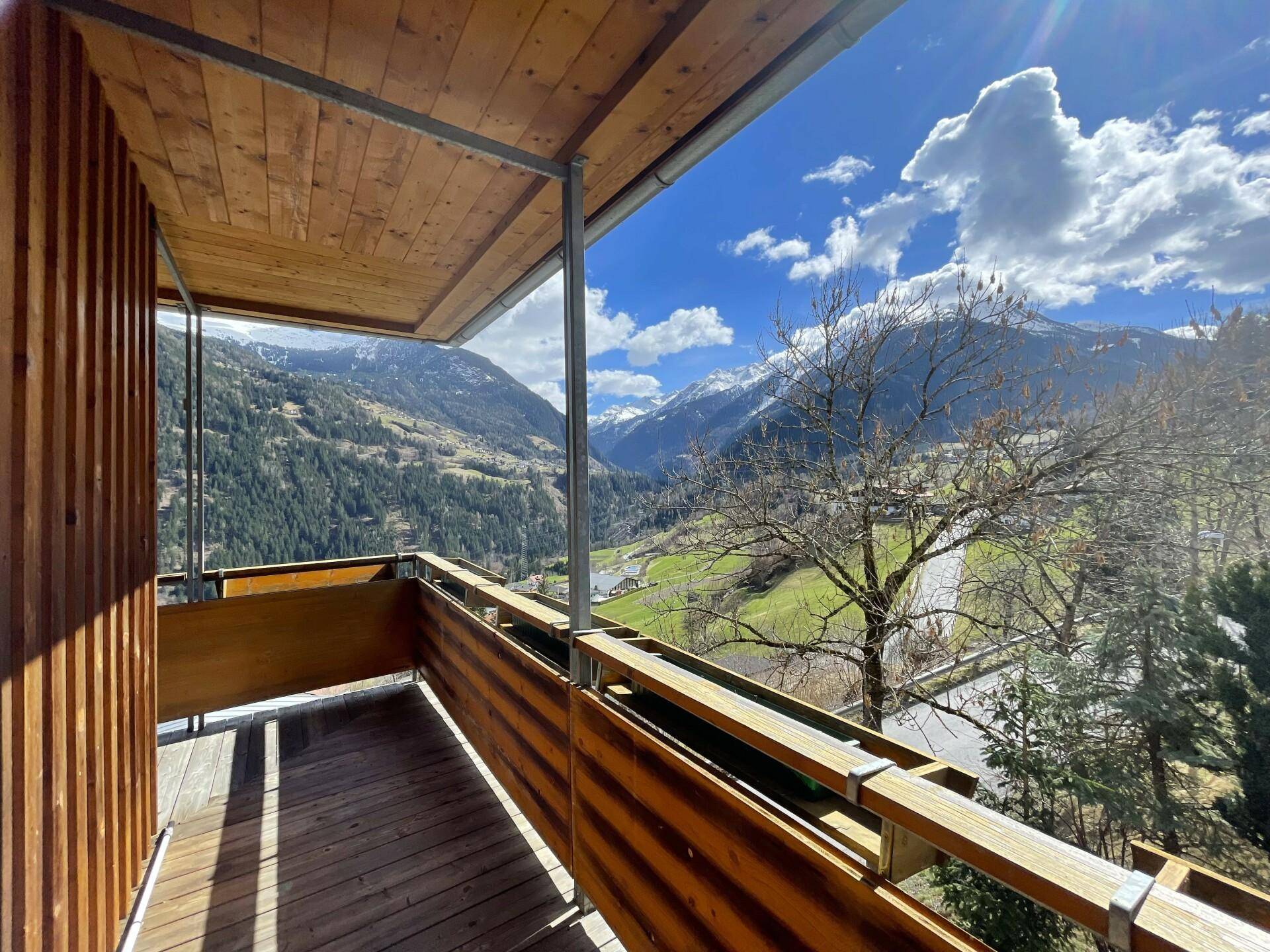 Geräumiger Holzbalkon mit schöner Aussicht auf die Berge und die umliegende Natur.