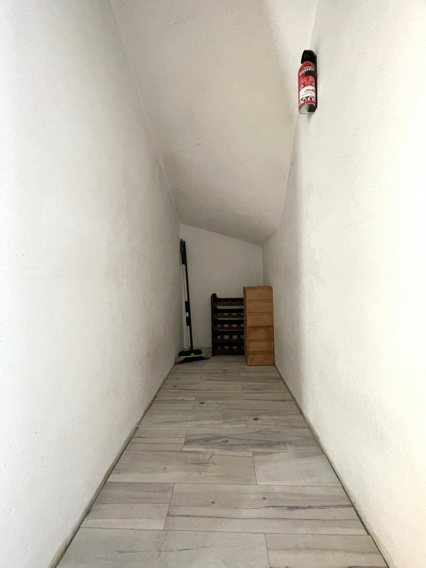 Praktischer Abstellraum mit schrägem Dach und Regalen für zusätzlichen Stauraum.