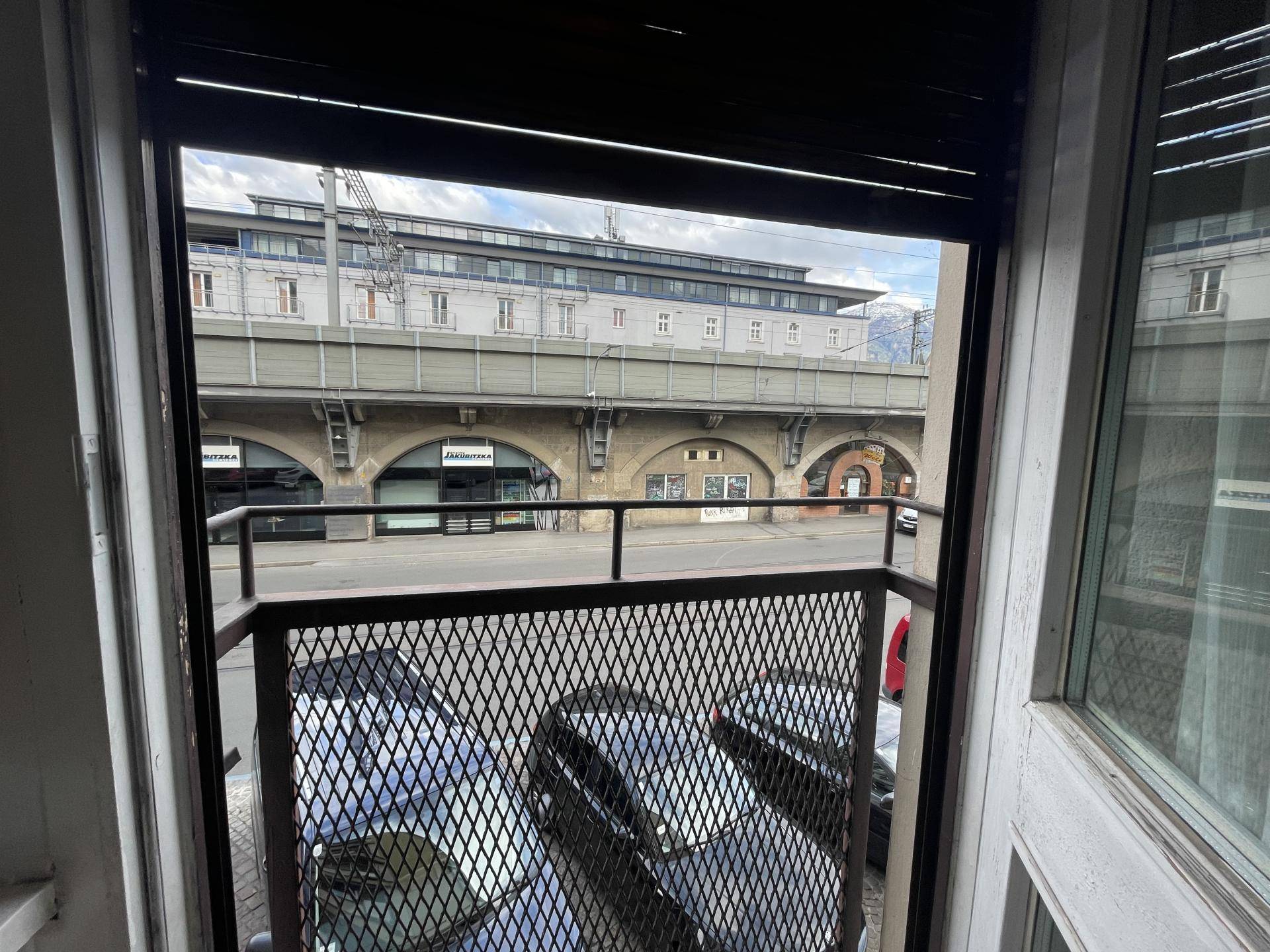 Blick von einem französischen Balkon auf die Straße und eine erhöhte Bahntrasse.