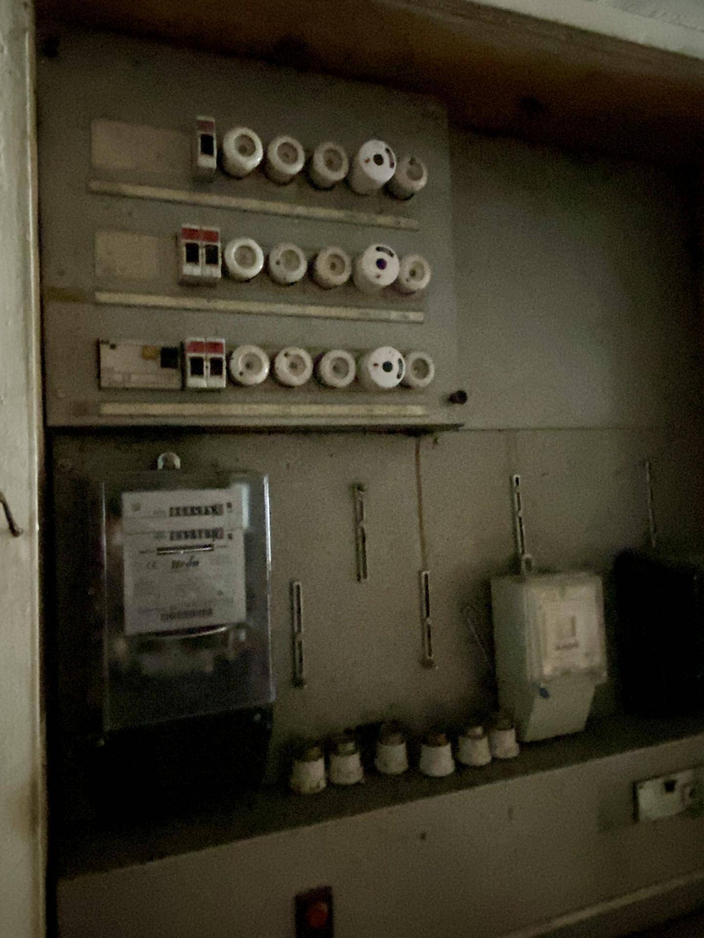 Elektrischer Sicherungskasten und Zähler in einem Versorgungsraum.