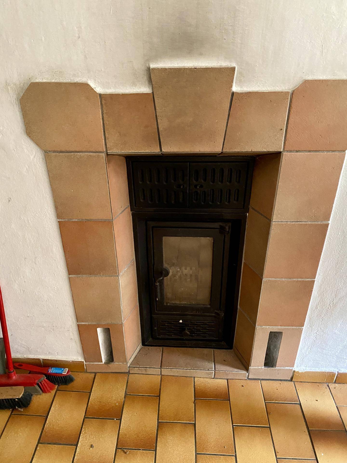 Eingebauter Kamin mit Fliesenverkleidung und rustikalem Charme.