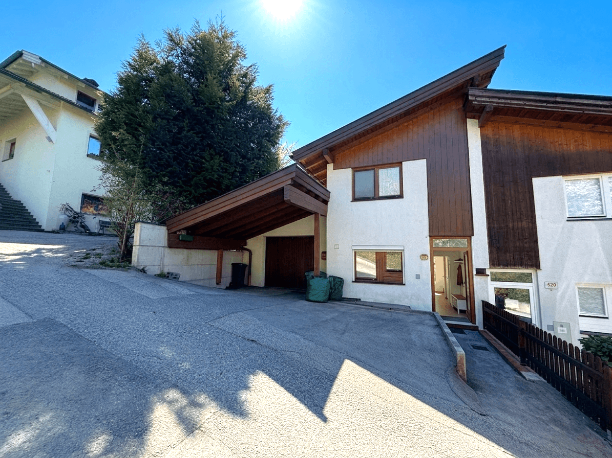 Außenansicht des Hauses von der Straße mit Zufahrt und überdachtem Carport.