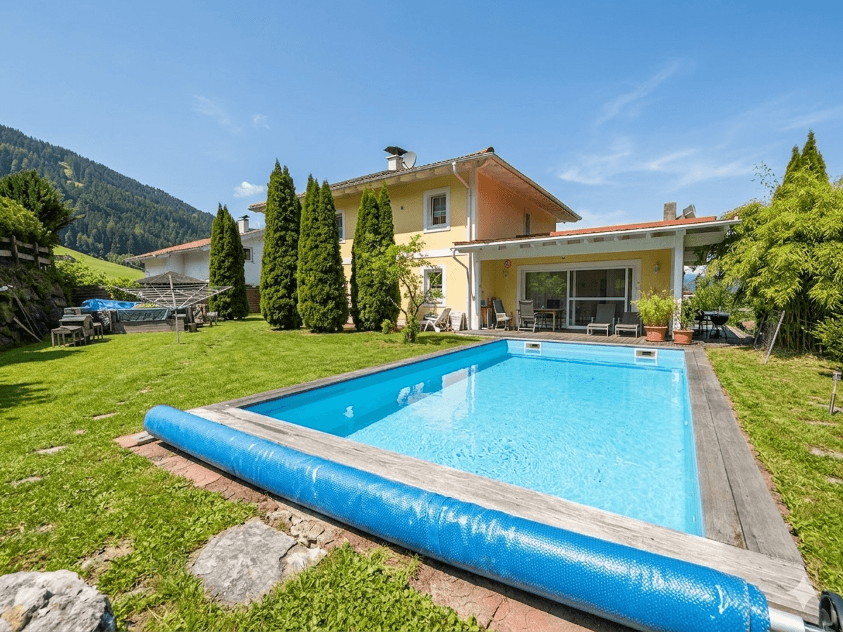 Großer Garten mit Swimmingpool, Liegewiese und Blick auf die umliegenden Hügel.